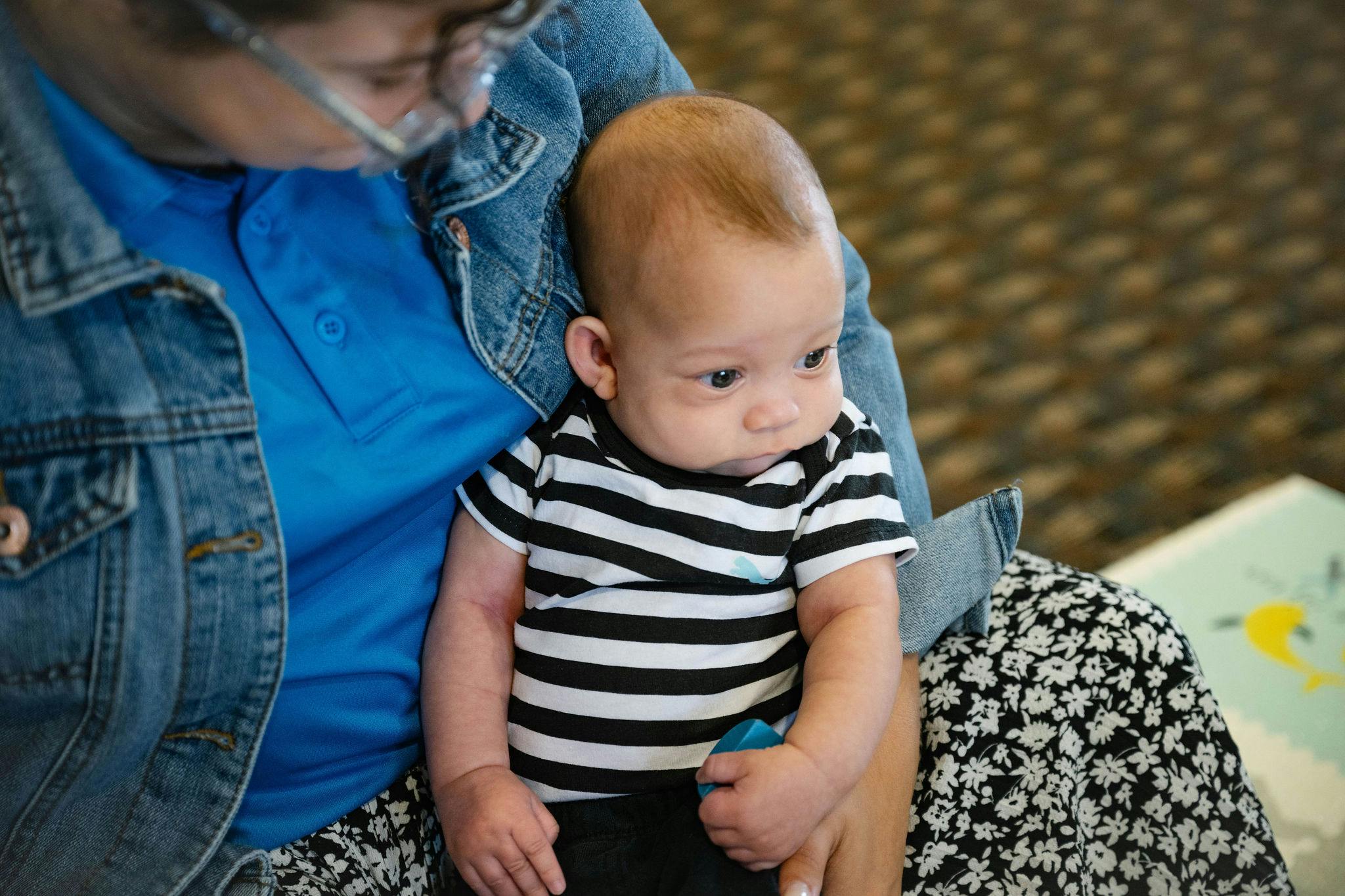 Person holding a child in a striped shirt