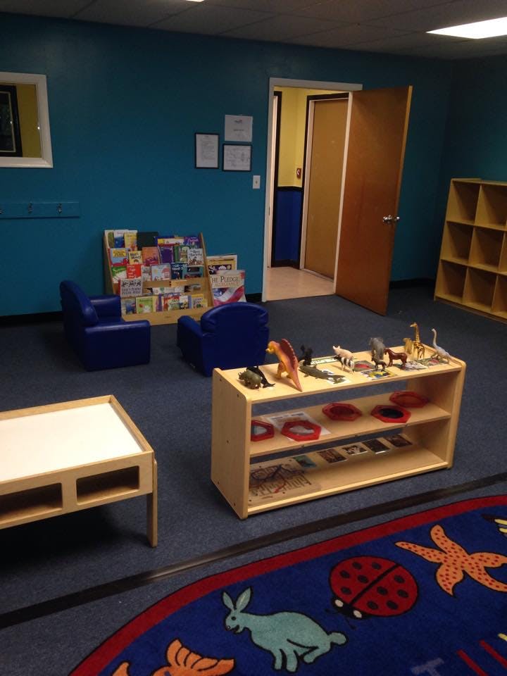 Children's play area with small chairs, bookshelves, and toy shelves