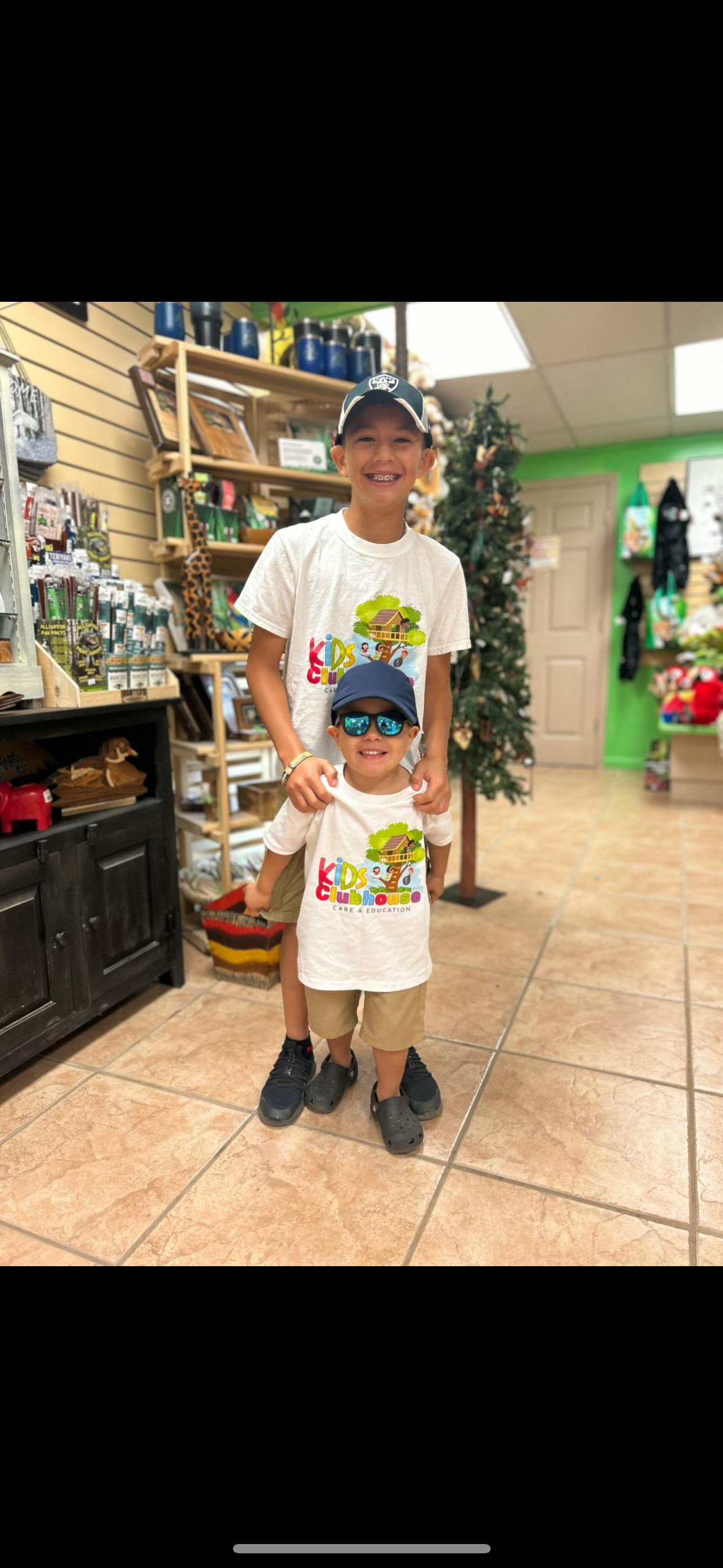 Two children wearing hats and sunglasses standing in a store