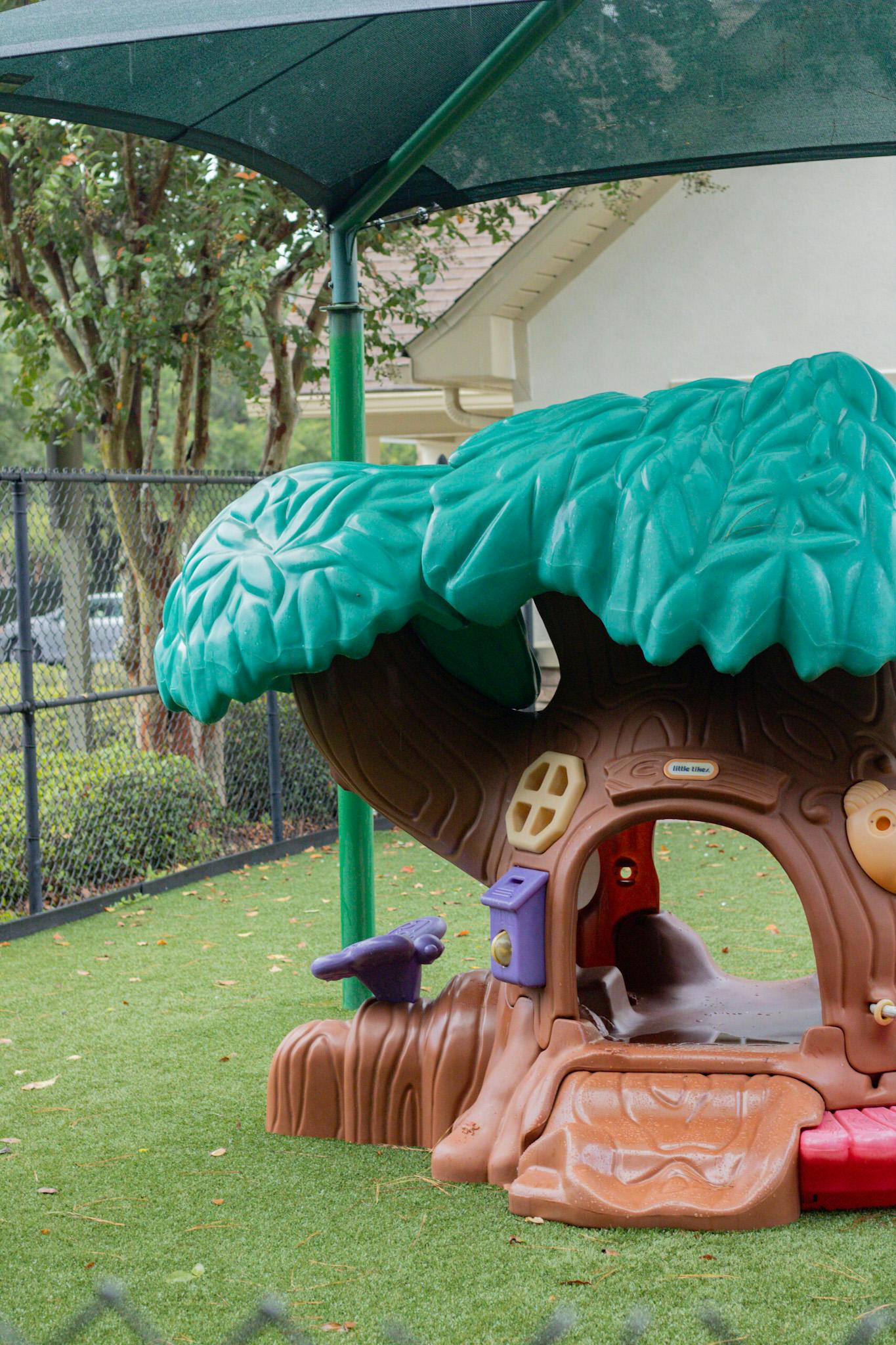 Playground with a tree-shaped play structure and green turf
