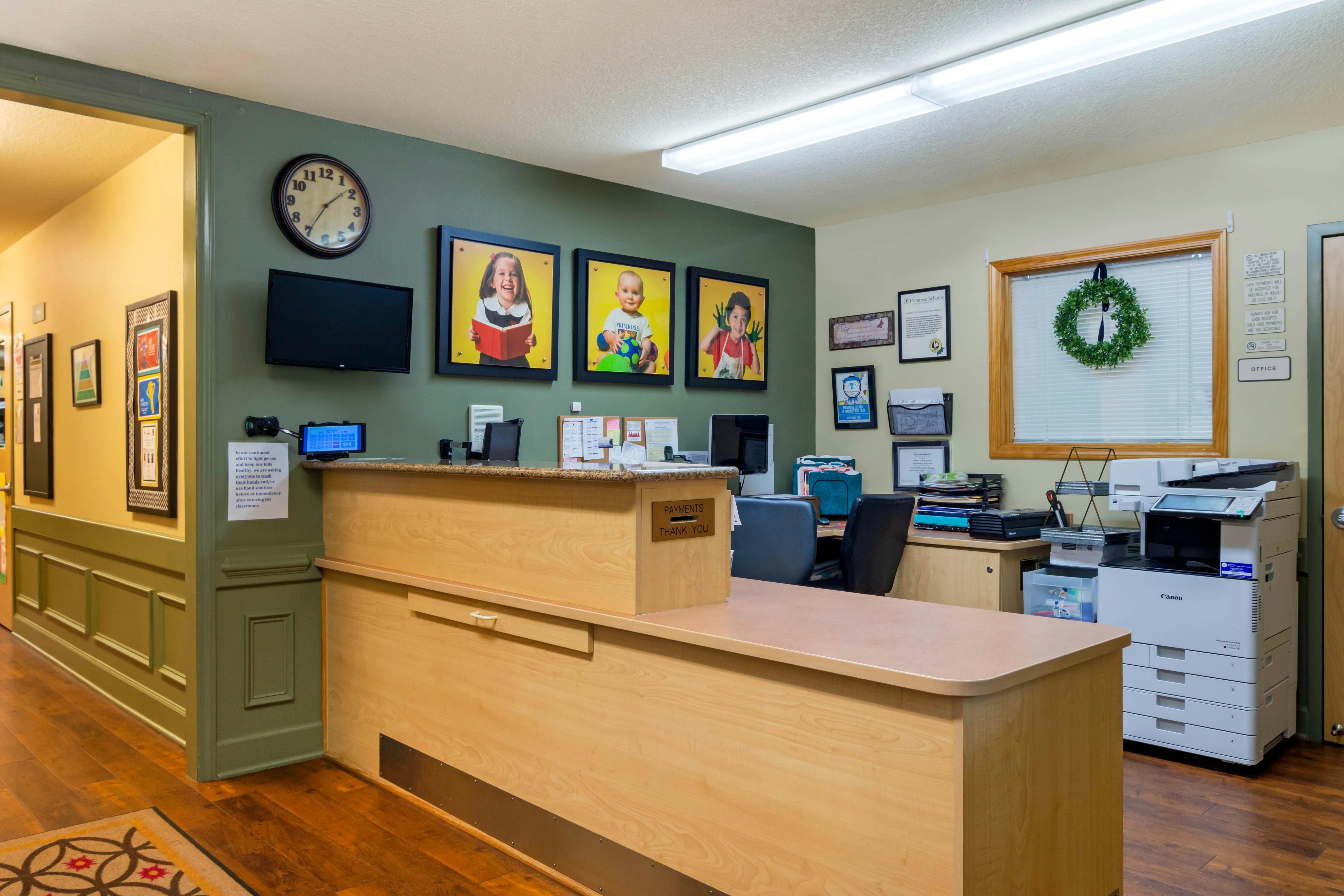 Reception desk area with child photos, sign that says "PAYMENTS THANK YOU"