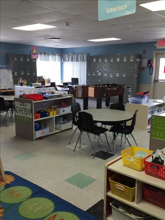 Classroom with tables, chairs, shelving units, and lockers