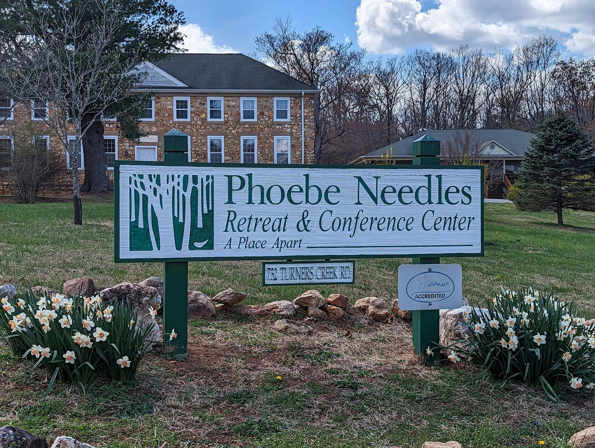 Sign for Phoebe Needles Retreat & Conference Center with building in background