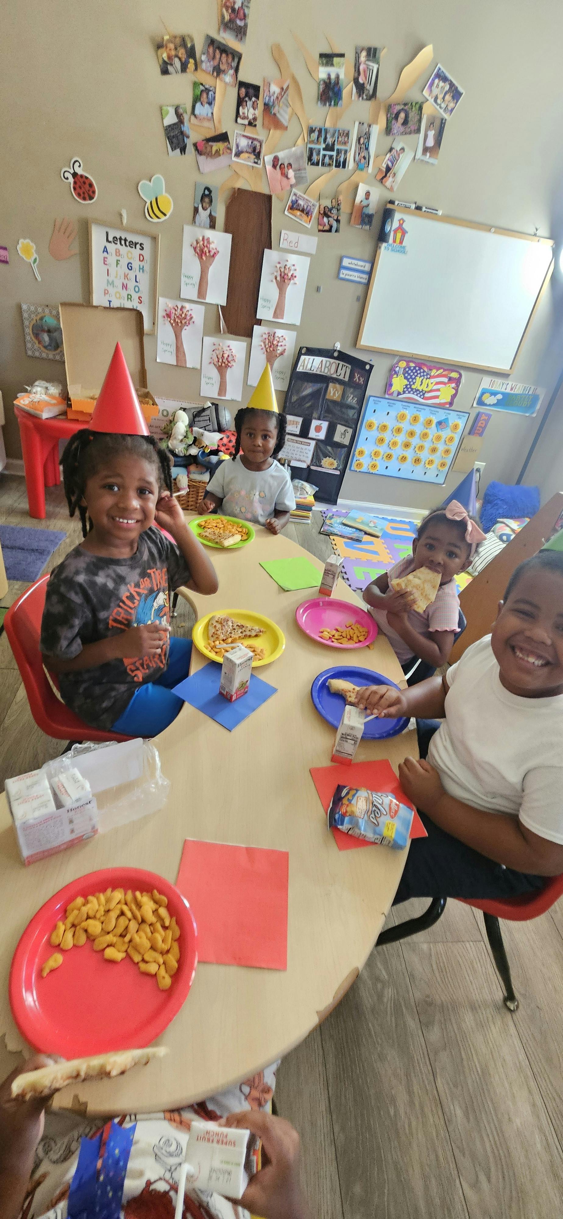 Children wearing party hats eating at a table