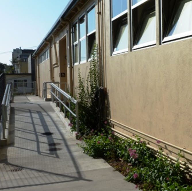 Building exterior with windows and a ramp with handrails