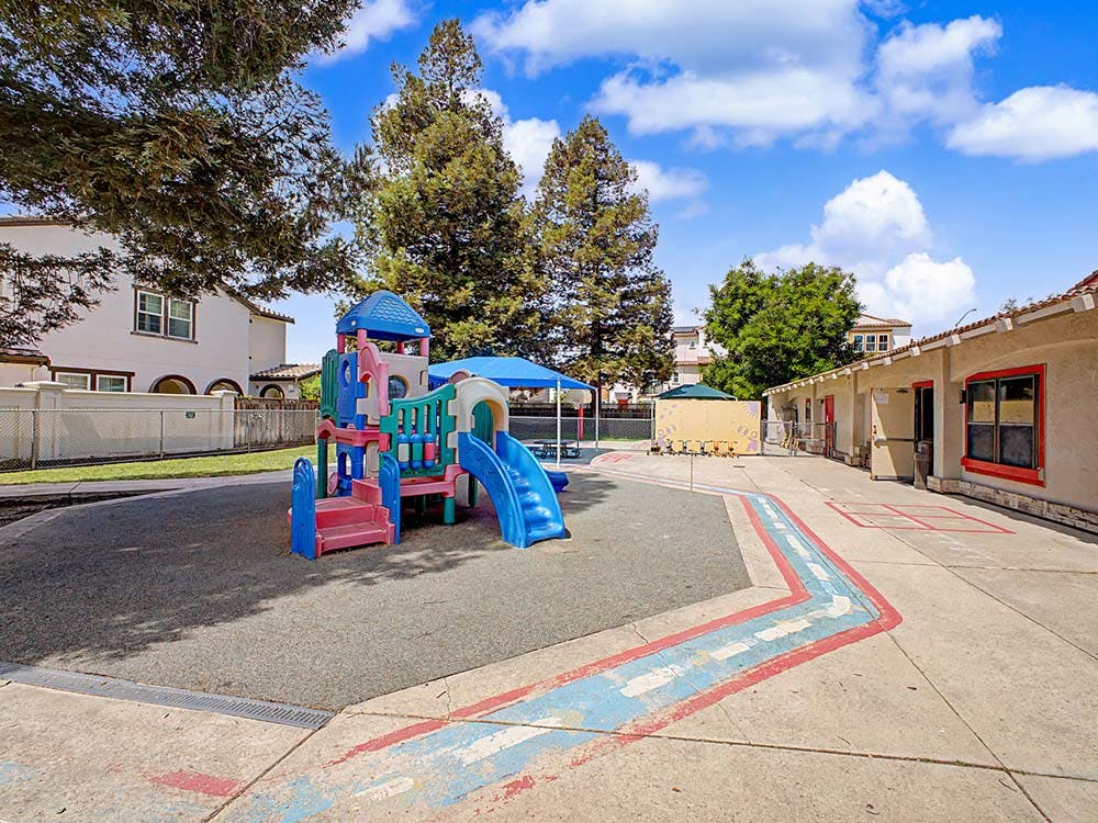 A colorful playground with slides and steps on a soft ground surface