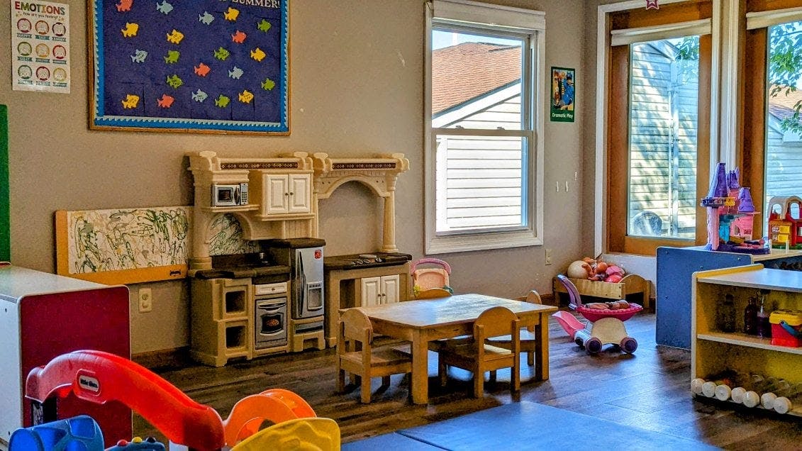 Playroom with toy kitchen, small table and chairs, and other toys