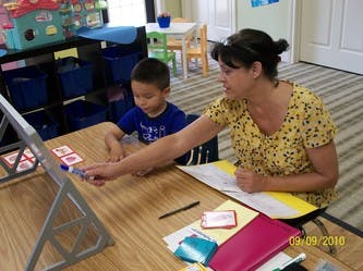 Adult and child at a table with an easel