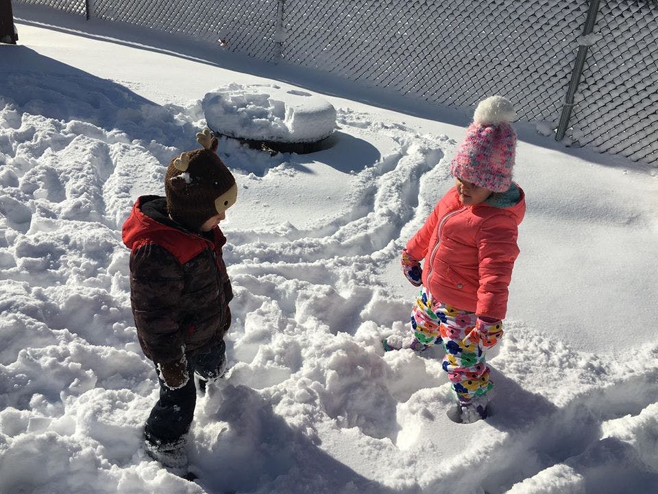 Two children standing in snow