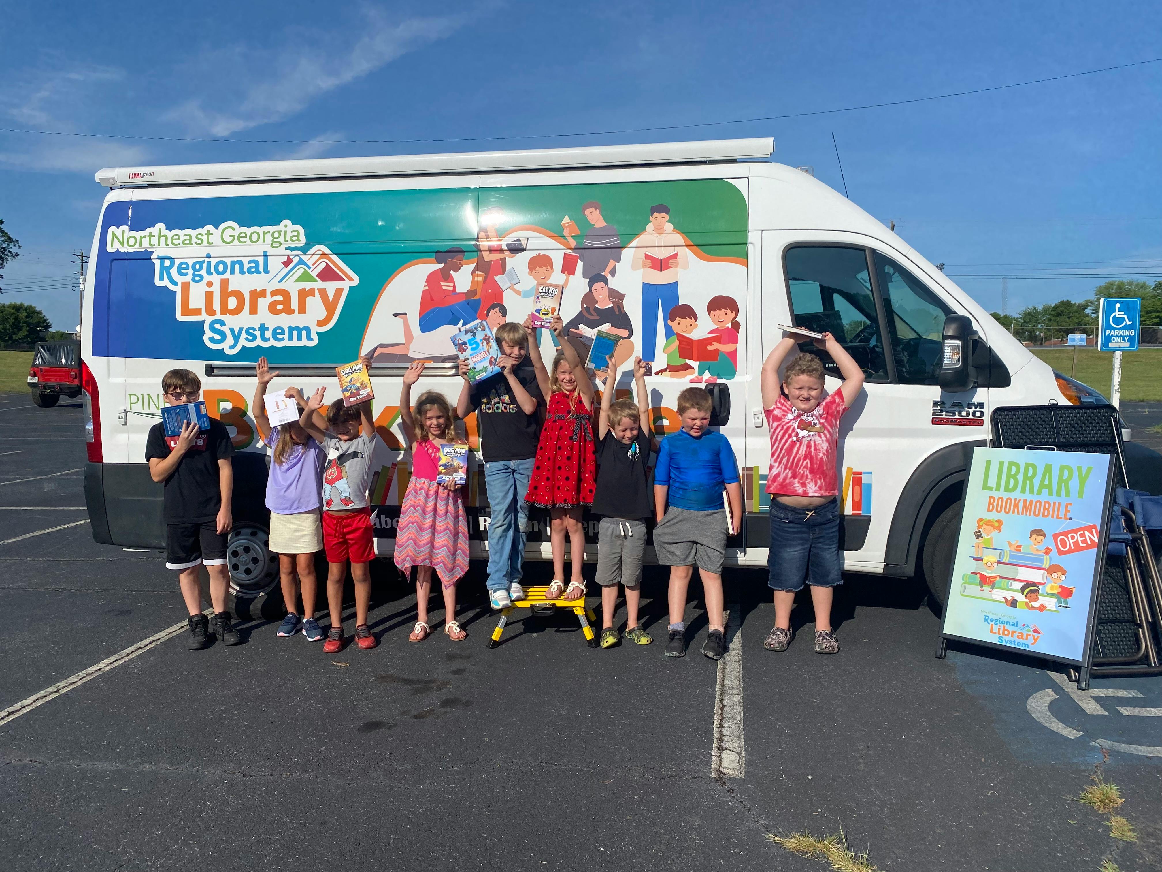 Children standing in front of a library van