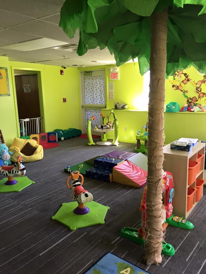 Indoor play area with toys and a faux tree