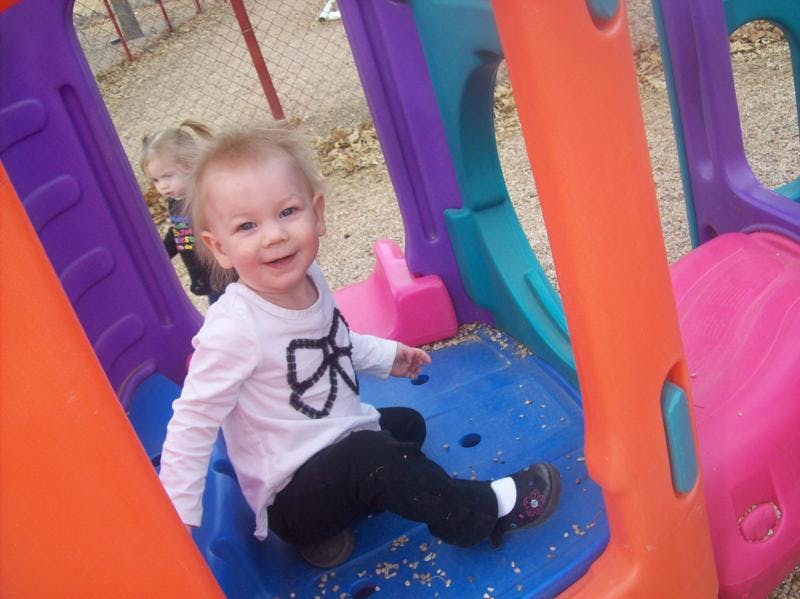 Child sitting on a colorful playground slide