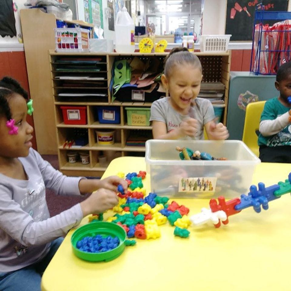 Children playing with colorful building blocks at a table