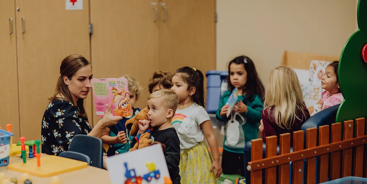 Person interacting with children in a classroom