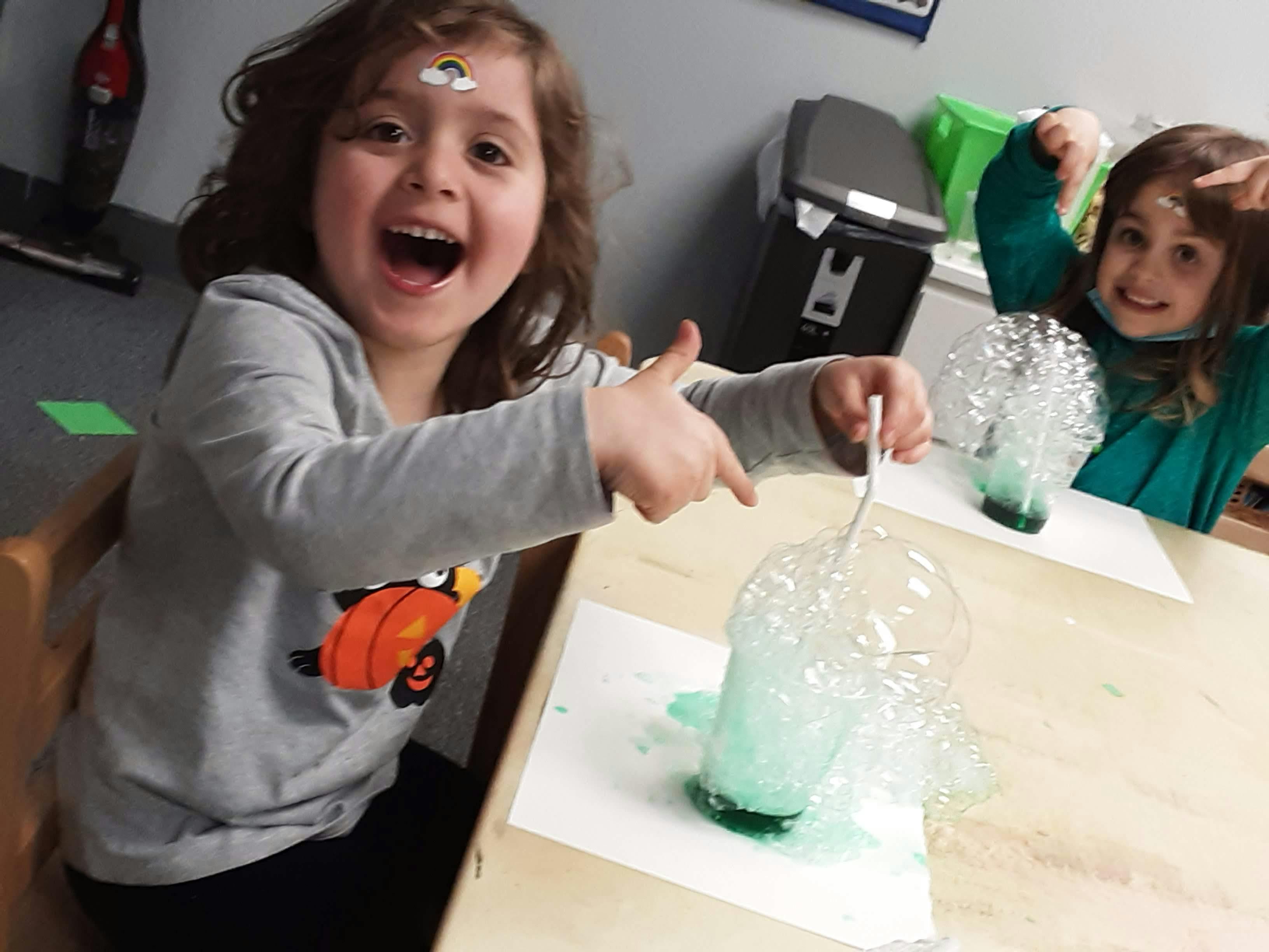 Two children doing a science experiment with bubbling liquid