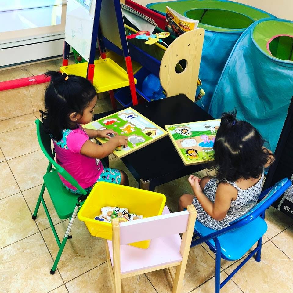 Two children playing with puzzles at a table
