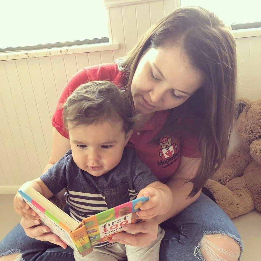 Person and child reading a book together