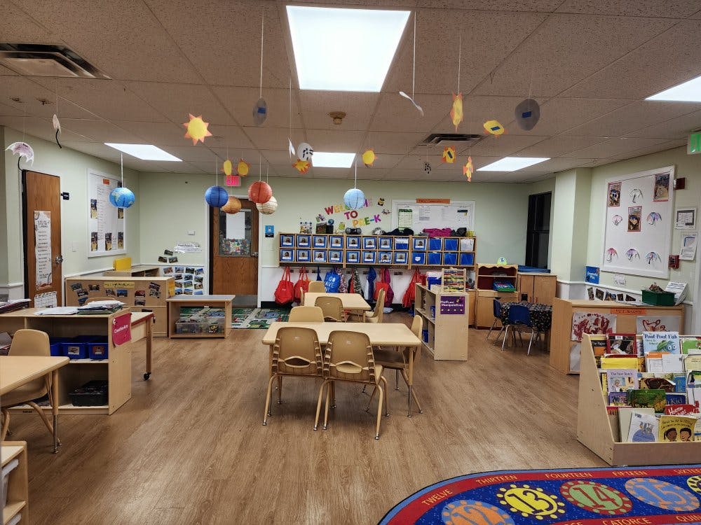 Empty colorful preschool classroom with small tables and chairs