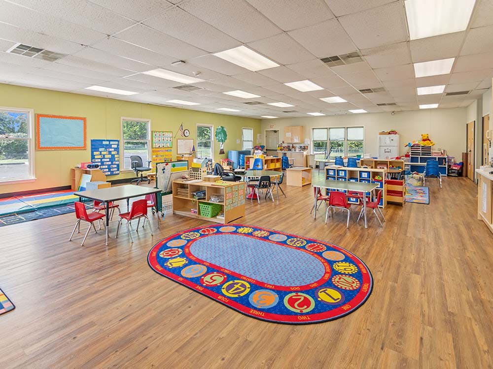 Classroom with tables, chairs, and play areas for children
