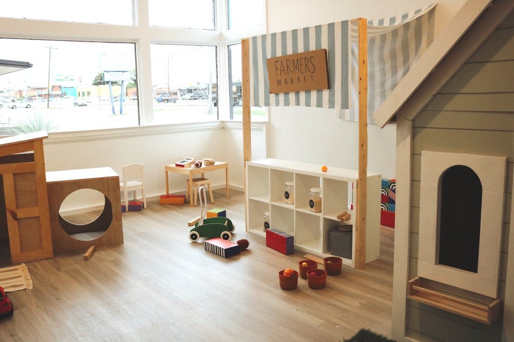 Playroom with toy market stand, playhouse, and wooden toys