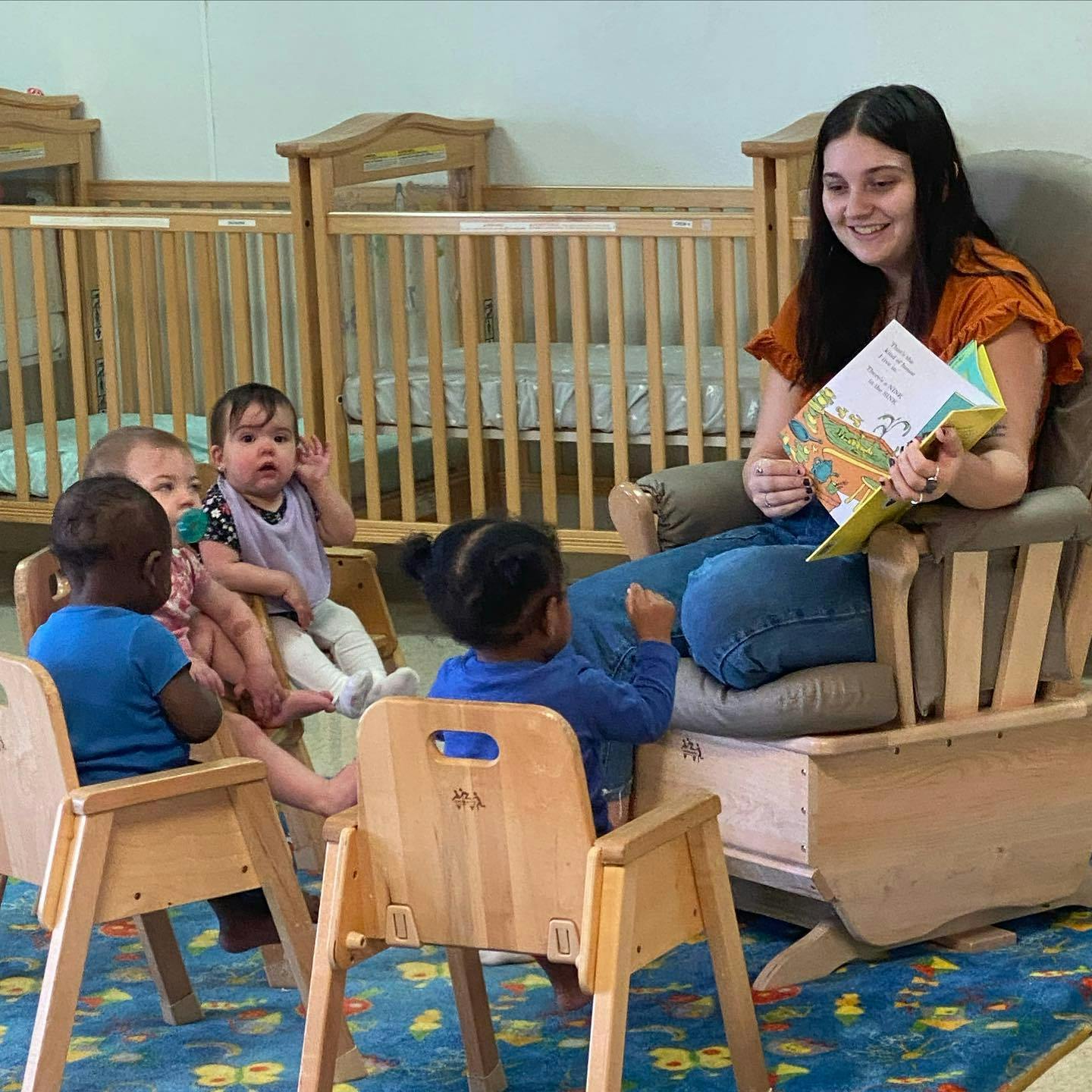 Person reading a book to children in a classroom