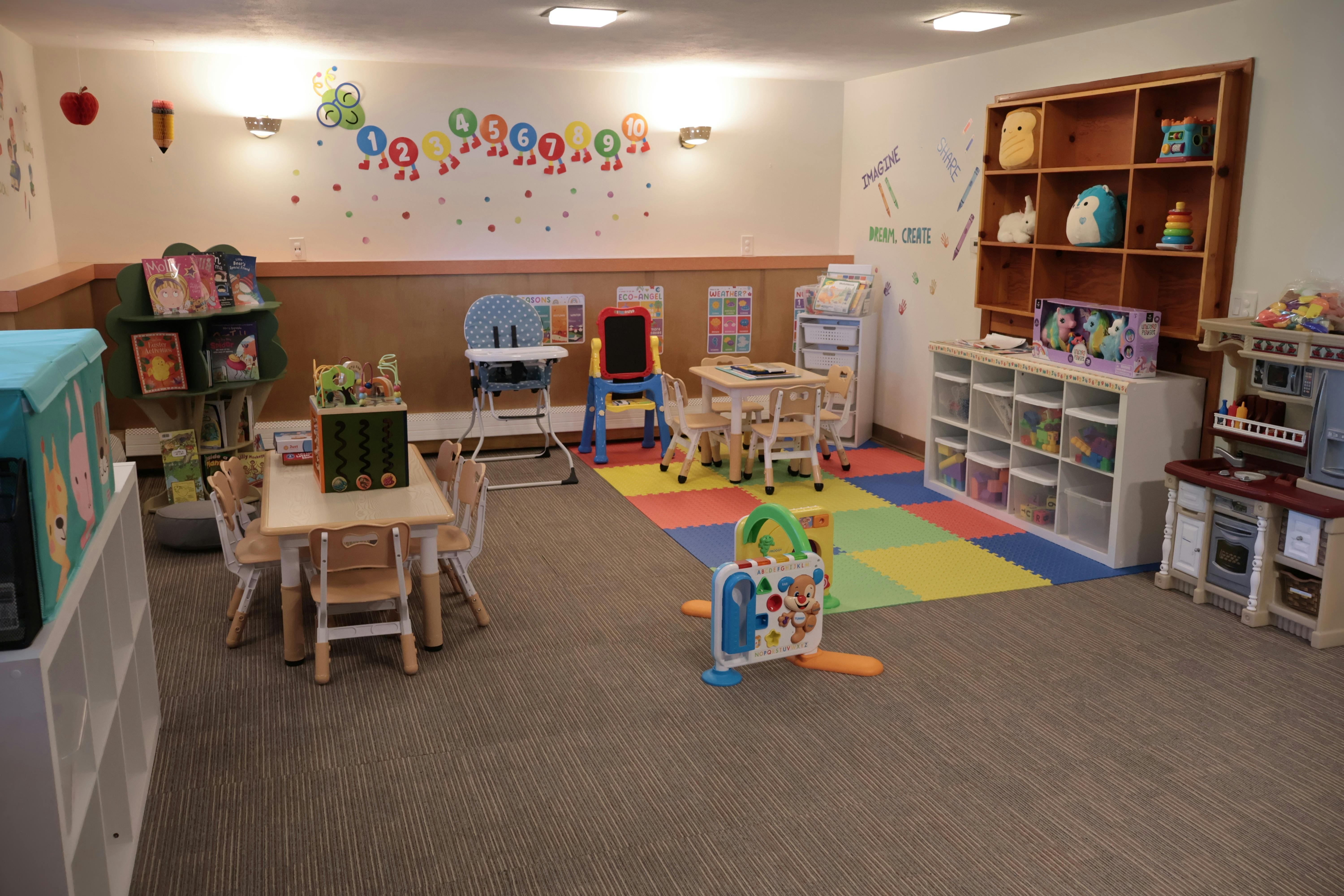 Children's playroom with small tables, chairs, and toys