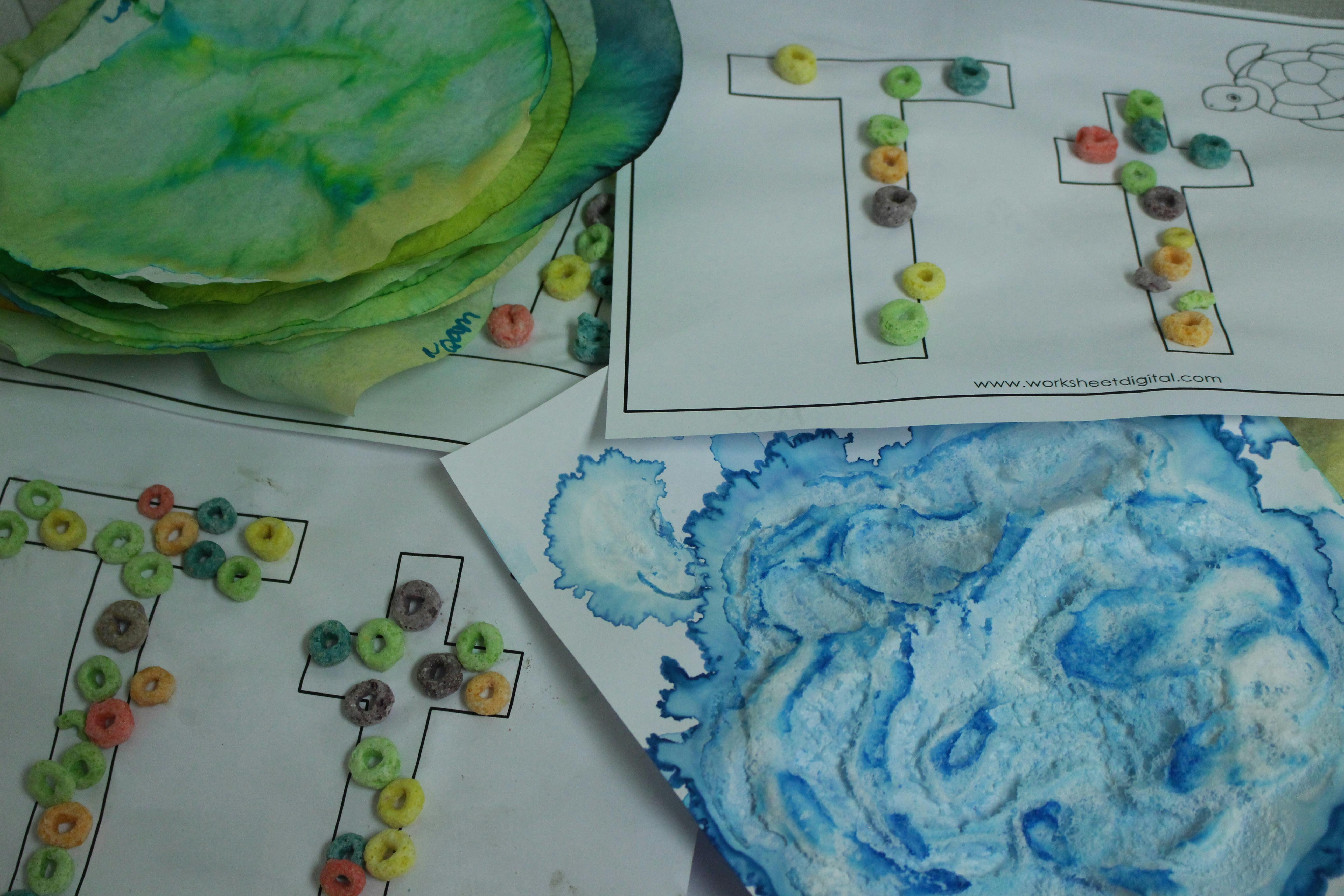 Children's craft projects with cereal on letter T outlines and painted paper