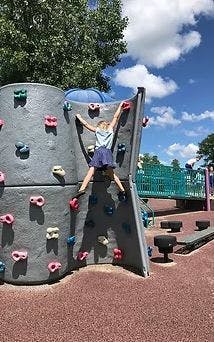 Child climbing a rock wall on a playground
