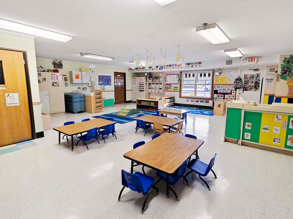 Empty classroom with small tables and chairs