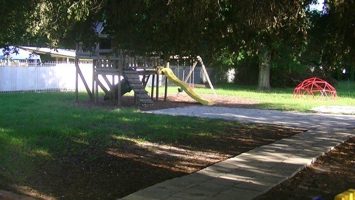 Playground with wooden structure, yellow slide, and red dome