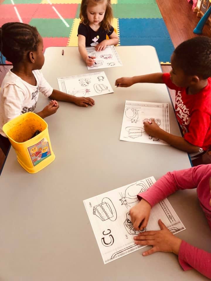 Children coloring at a table in a classroom