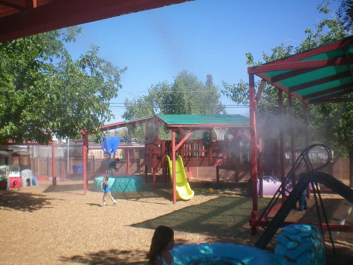 Child playing in a playground with misting system