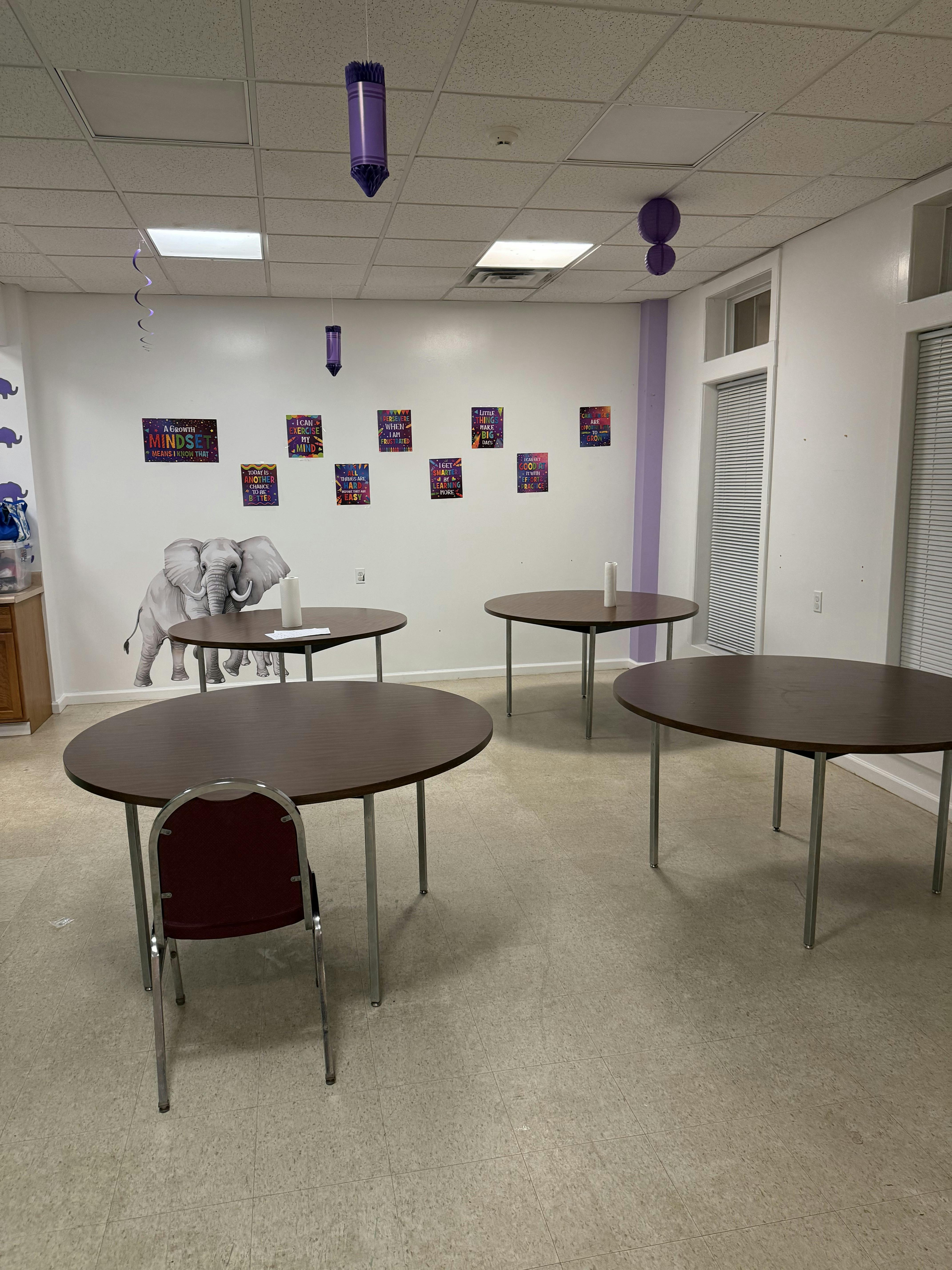 Empty room with several round tables and one chair