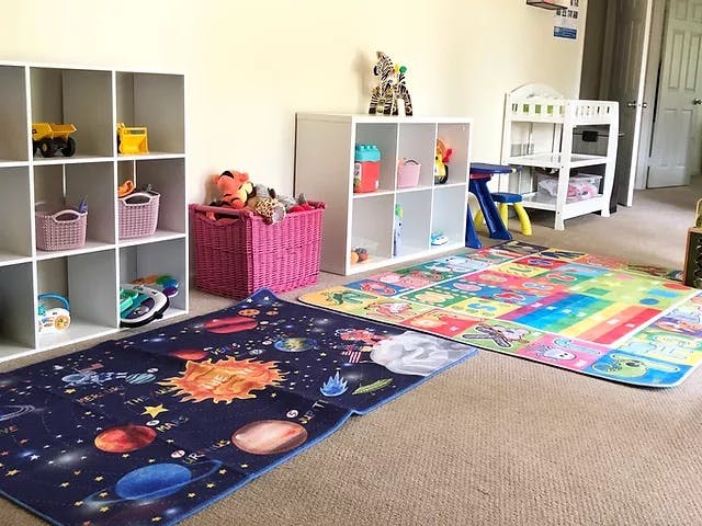 Playroom with colorful rugs, storage shelves, and toys