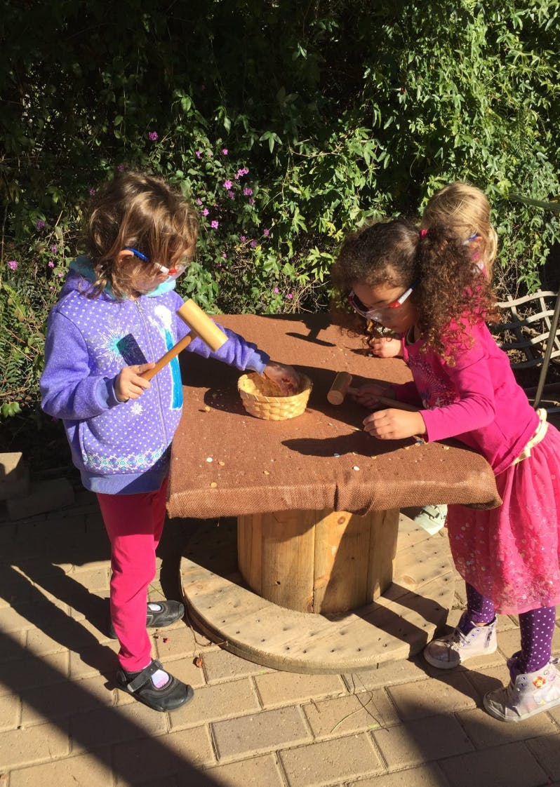 Two children playing at a table outdoors