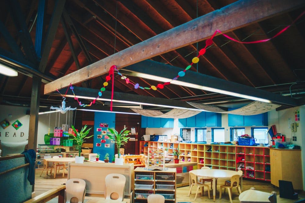 Classroom with tables, chairs, and shelves with cubbies