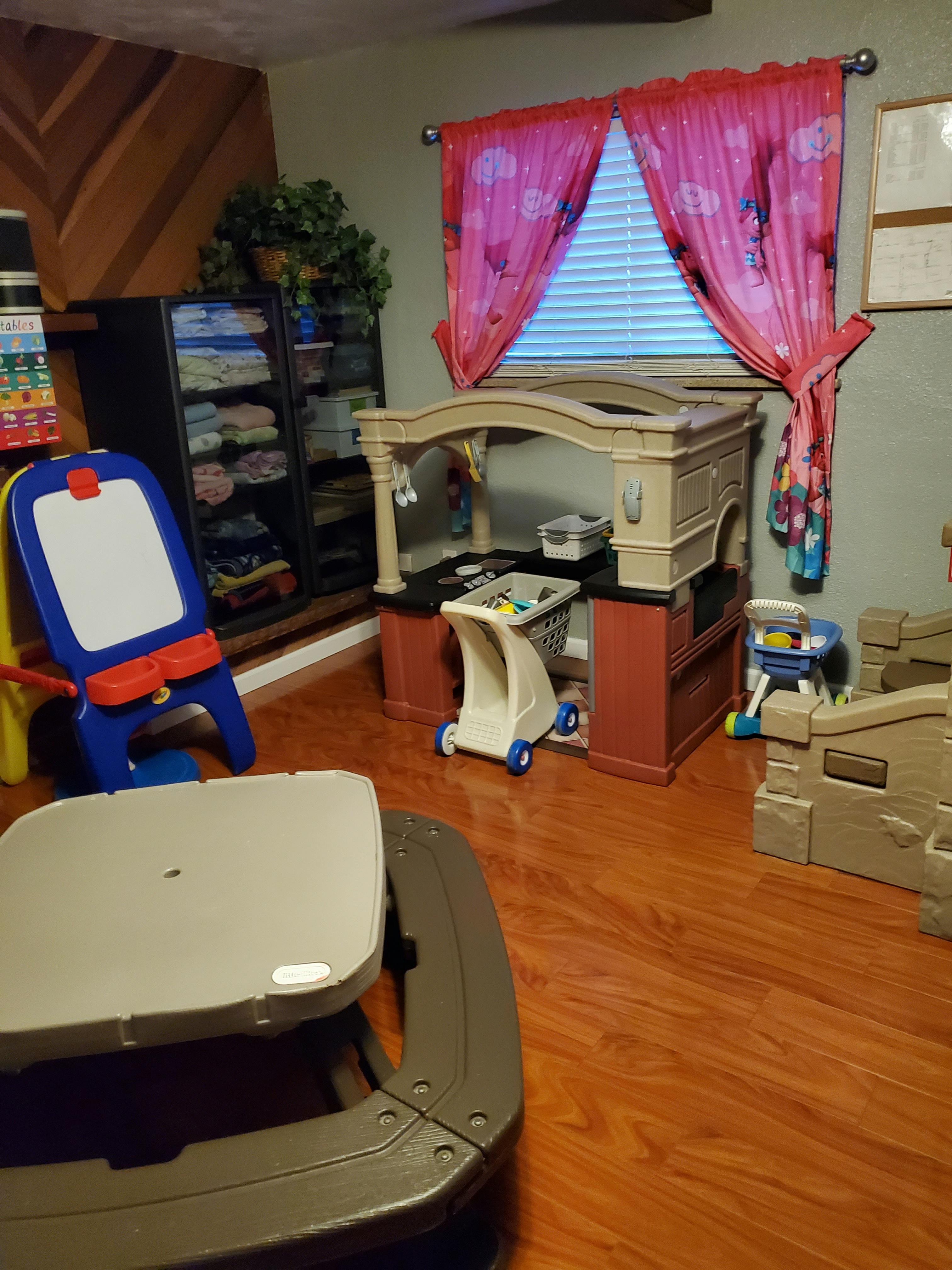 Children's play area with various toys and furniture