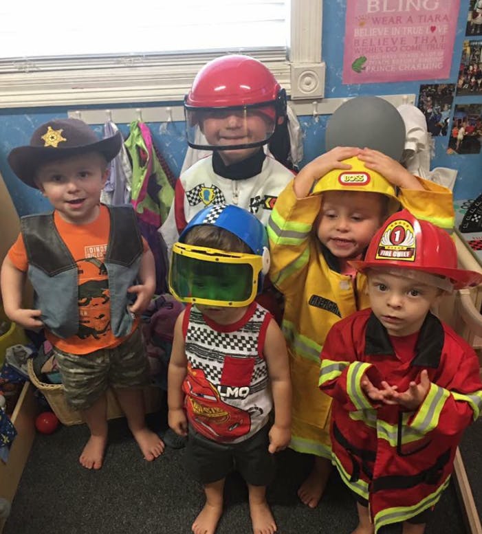 Five children in various costumes including a cowboy, race car driver, and firefighters