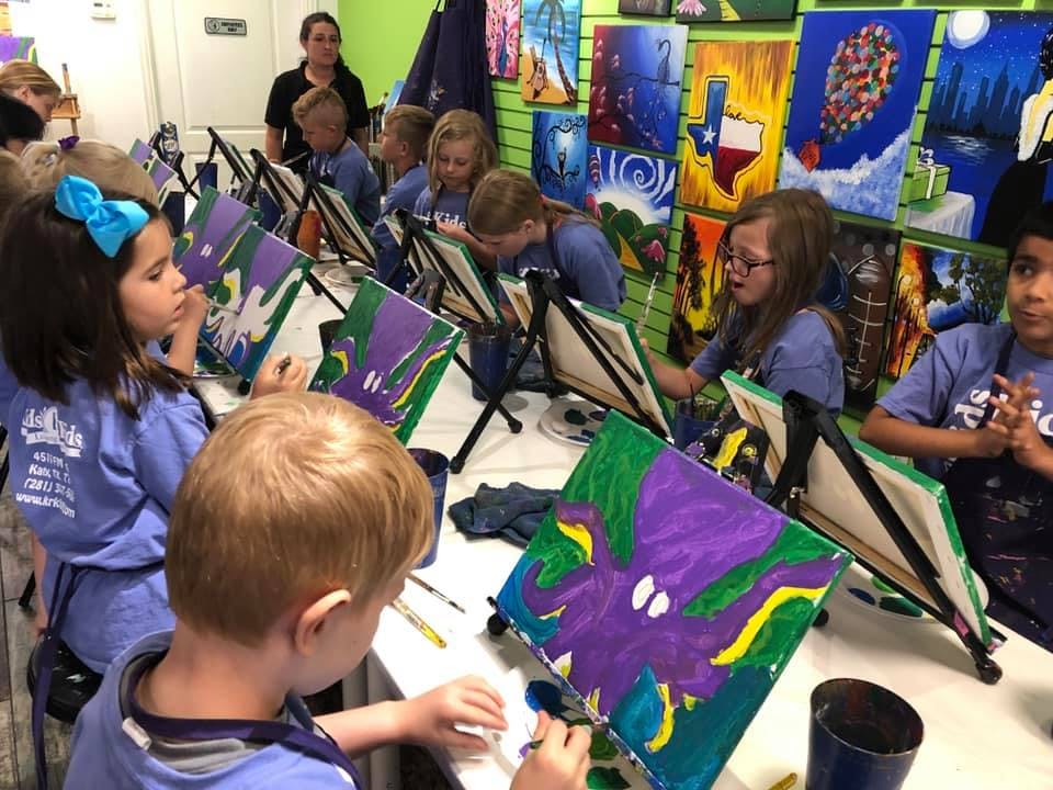 Children painting at easels in a classroom