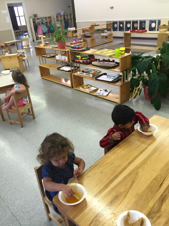 Children eating at tables in a classroom