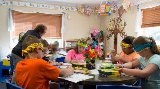 Adult and children at a table in a classroom