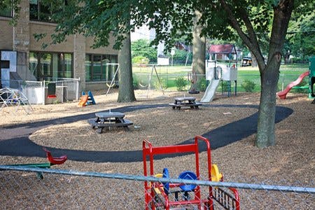 Outdoor playground with slides, swings, and picnic tables