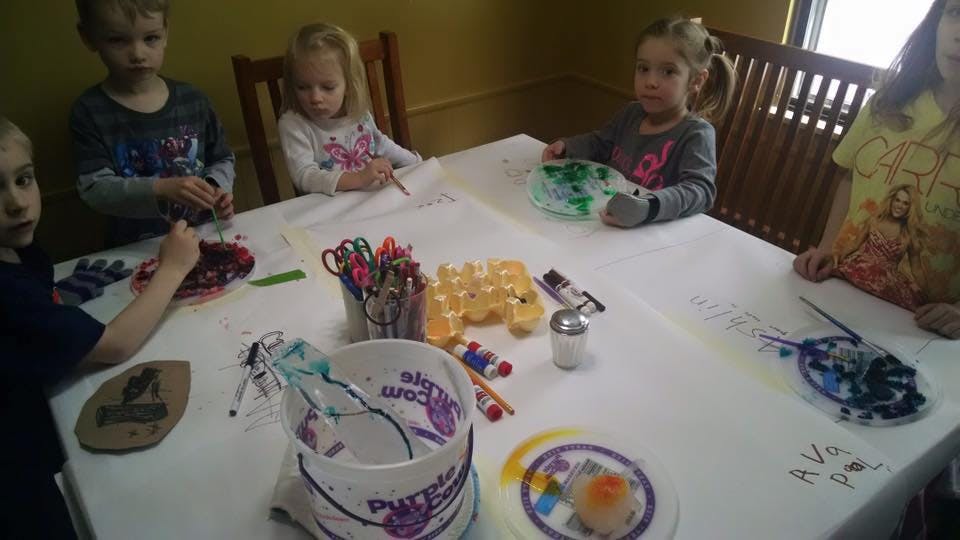 Children sitting around a table with art supplies