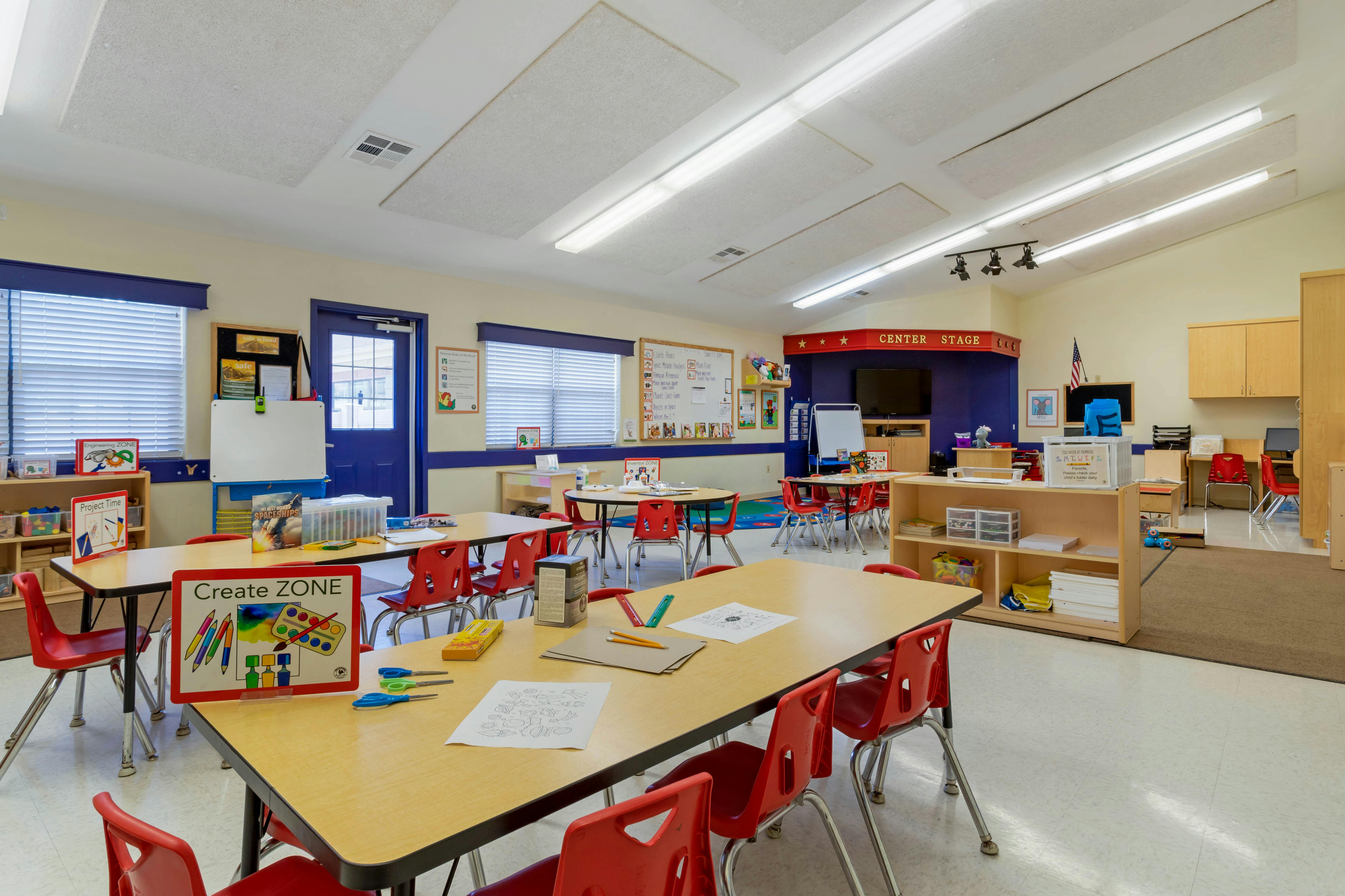 Classroom with tables, red chairs, and a sign reading "Create ZONE"
