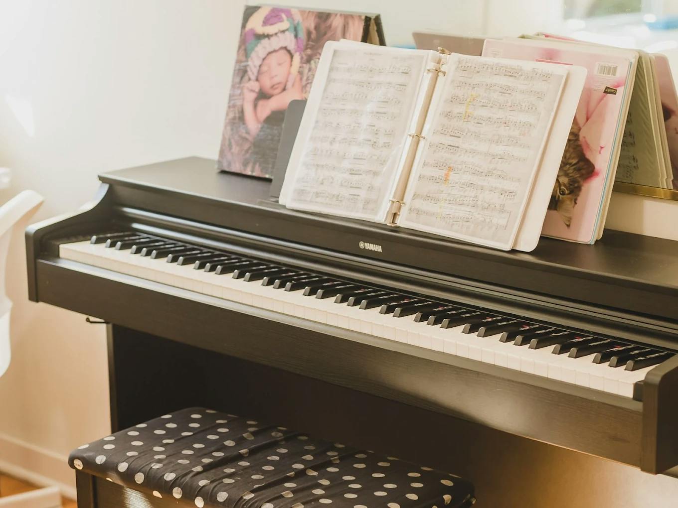 Digital piano with sheet music and a polka dot bench