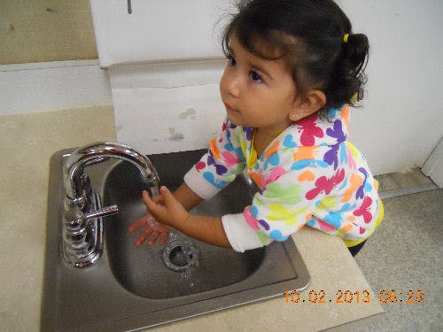 Child washing hands at a sink