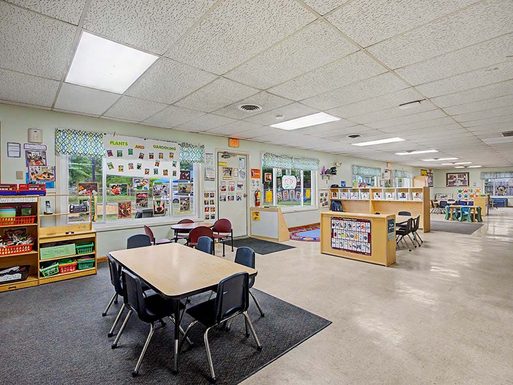 Empty classroom with tables, chairs, and shelves