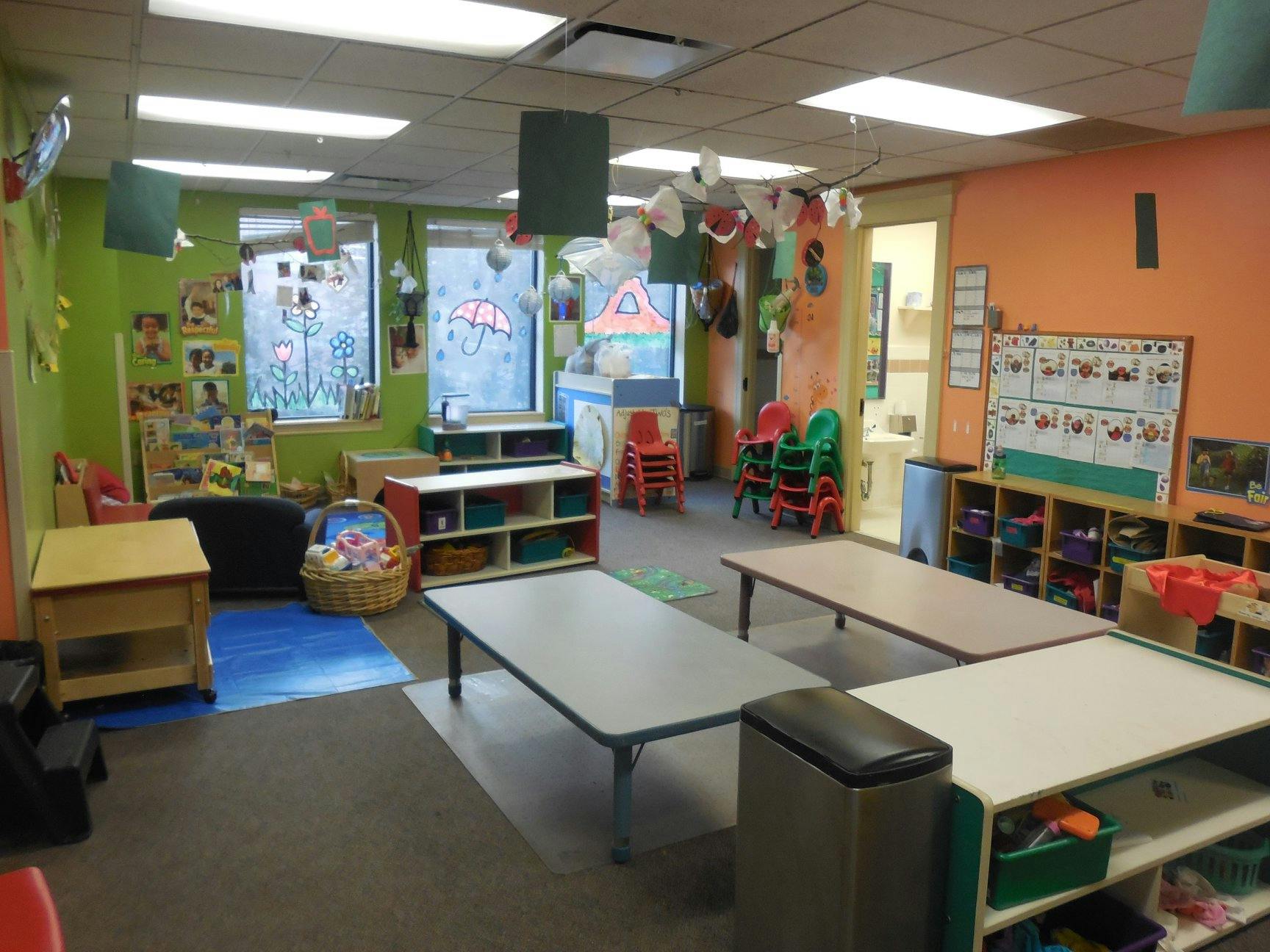 classroom with tables, chairs, and shelves