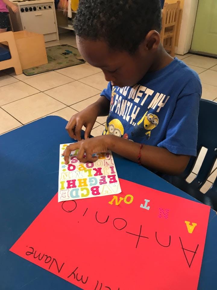 Child at a table working with alphabet stickers