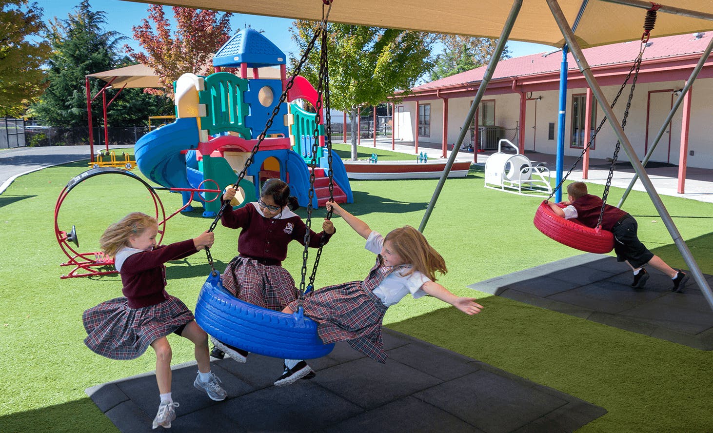 Children playing on swings and playground equipment